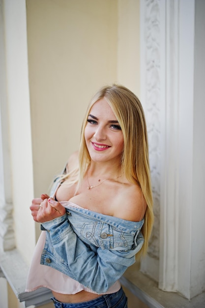 Free Photo blonde girl wear on jeans posed against old house