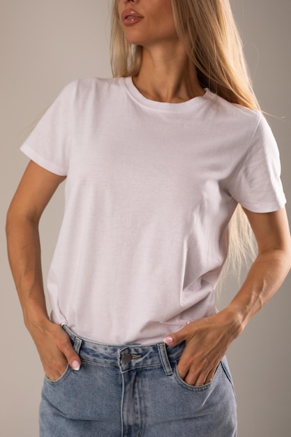 Free photo blonde girl in white tshirt and jeans posing on white background