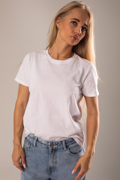 Free Photo blonde girl in white tshirt and jeans posing on white background