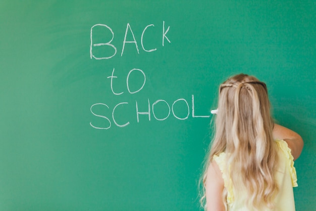 Free Photo blonde girl writing on chalkboard