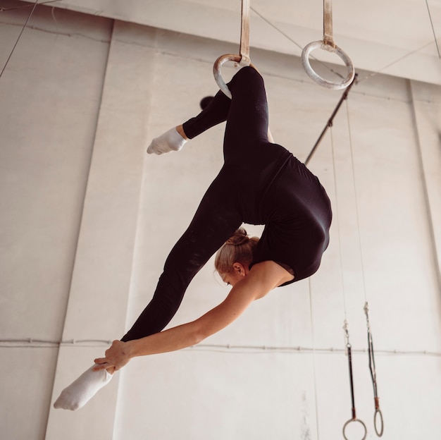 Blonde gymnast doing a complicated exercise