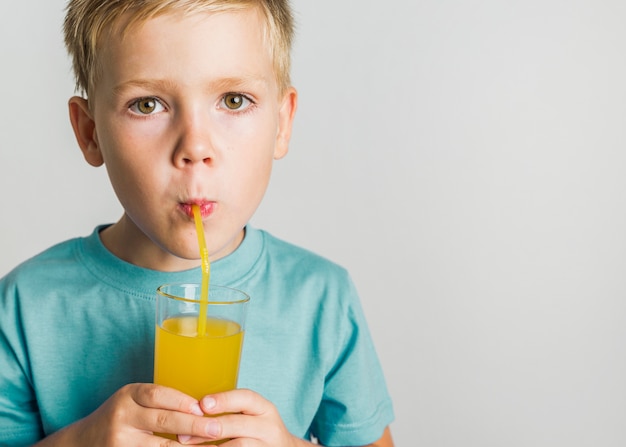 Blonde hair kid drinking juice