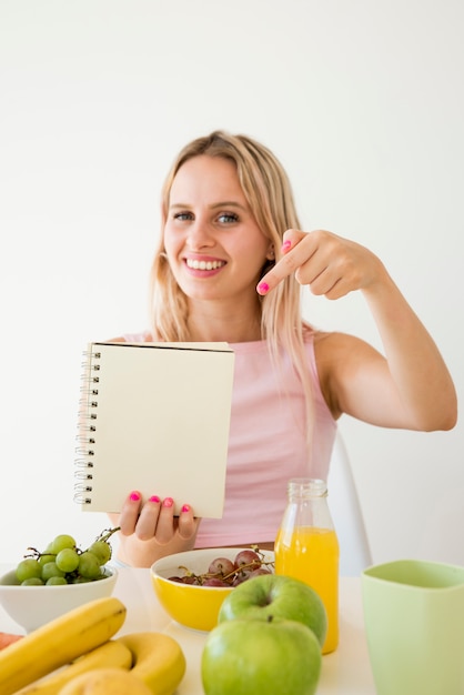 Free Photo blonde influencer showing notebook