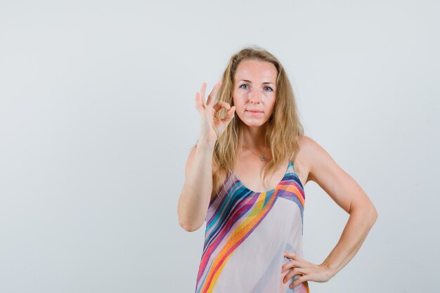 Free Photo blonde lady showing ok gesture in summer dress and looking confident 