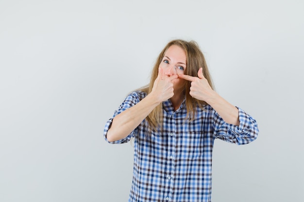 Free Photo blonde lady squeezing her pimple on cheek in shirt ,