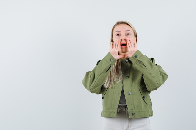 Free Photo blonde lady telling secret or announcing something in jacket, pants and looking excited. front view.