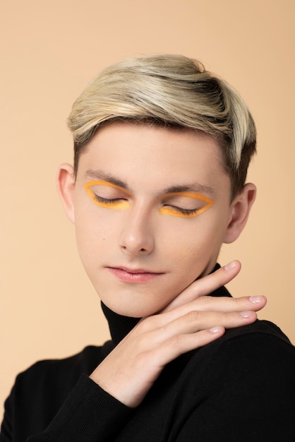 Blonde man wearing orange eyeliner