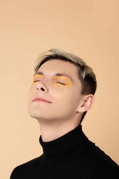 Blonde man wearing orange eyeliner