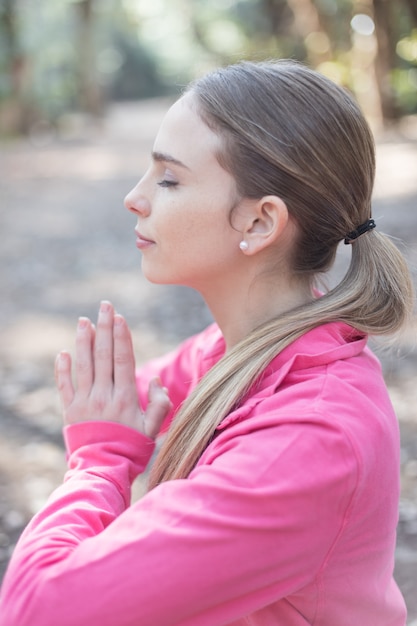 Free photo blonde teen meditating in nature