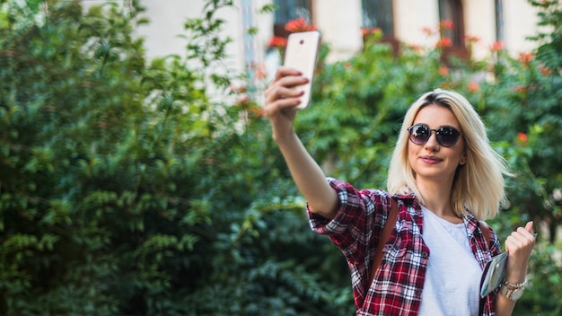 Free Photo blonde tourist taking selfie