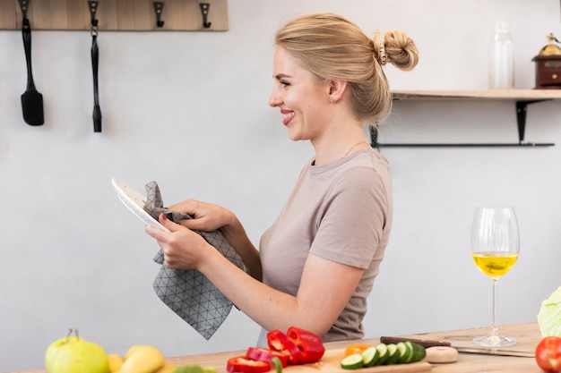 Free photo blonde woman cleaning the plate