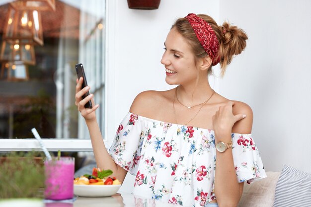 Blonde woman in floral dress in cafe