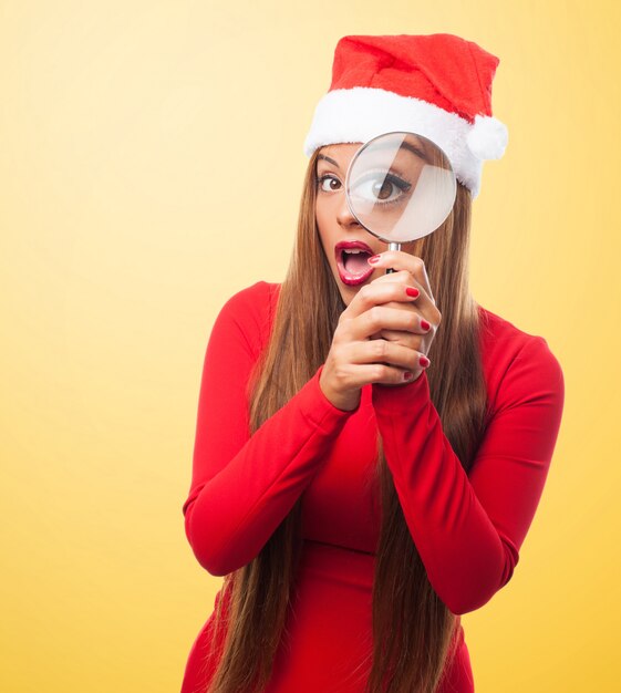 Blonde woman holding a magnifying glass with yellow background