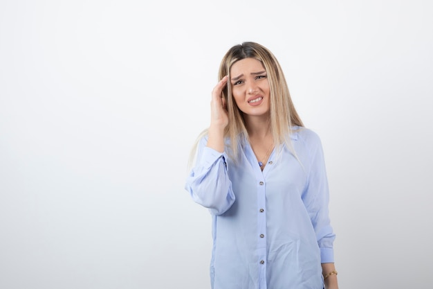 blonde woman looking at camera on white background.