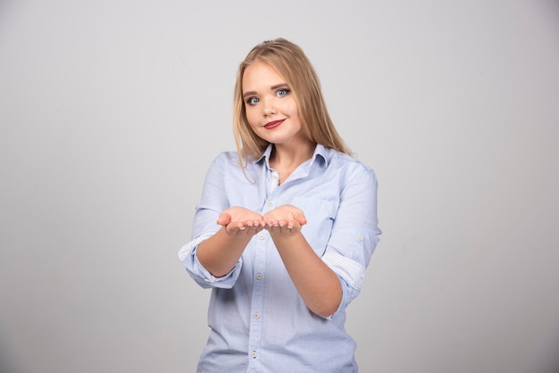 Blonde woman opened her hands for giving something