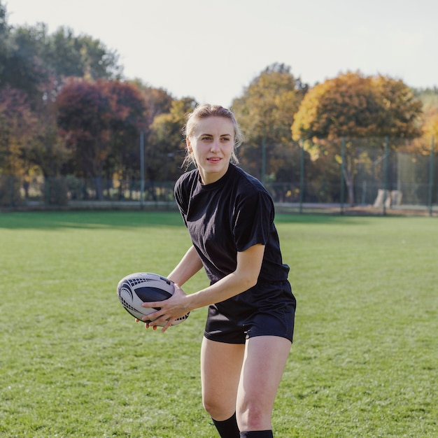 Blonde woman preparing to throw a rugby ball