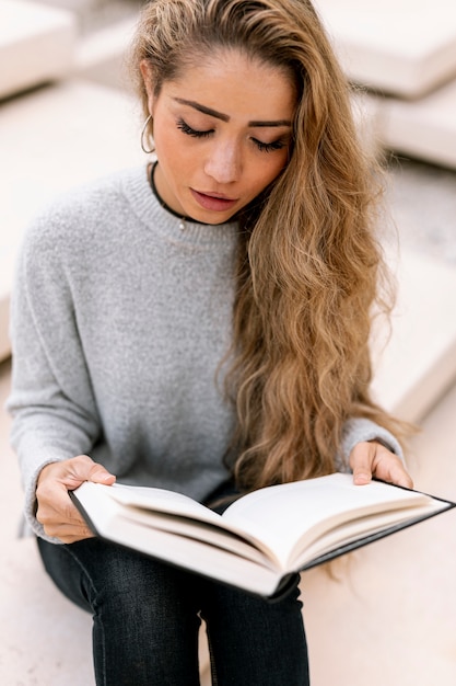 Free photo blonde woman reading her book