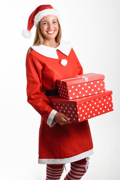 Blonde woman in Santa Claus clothes smiling with gift boxes.