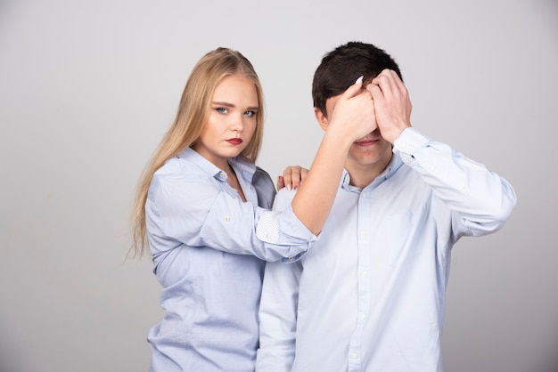 Blonde woman standing and closing eyes to guy model in white t-shirt