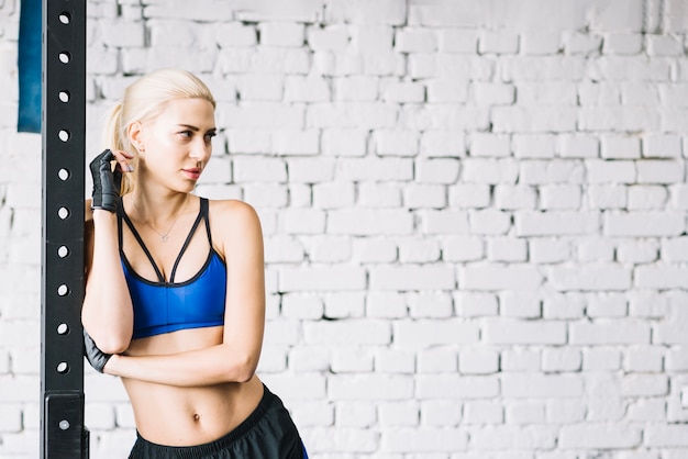 Free photo blonde woman standing near crossfit rack