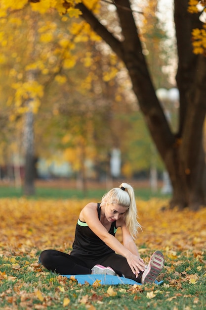 Blonde woman stretching outside