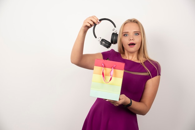 Free Photo blonde woman taking headphones out of bag with happy expression.