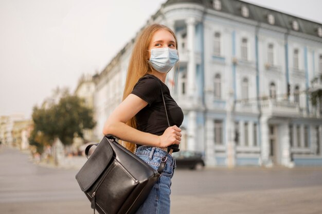 Blonde woman wearing a medical mask outside