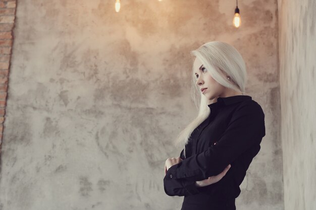 Blonde woman with black dress posing