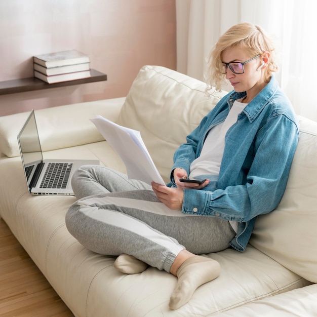 Blonde woman working on couch