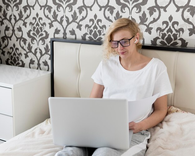 Blonde woman working on laptop and drinking coffee