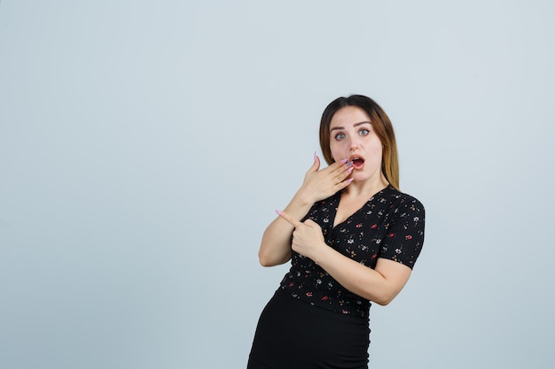 Blonde young lady in dress gesturing isolated