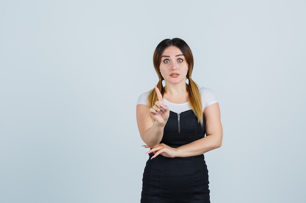 Blonde young lady in dress gesturing isolated