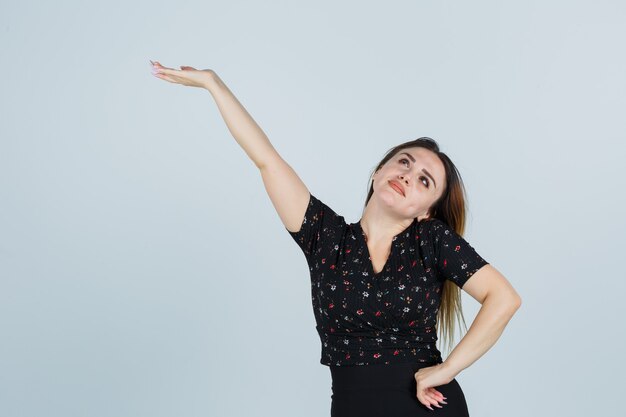 Blonde young lady in dress gesturing isolated