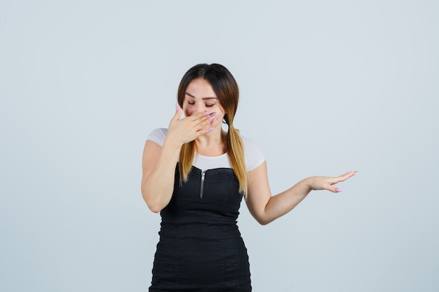 Blonde young lady in dress gesturing isolated