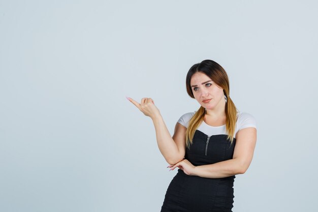 Blonde young lady in dress gesturing isolated