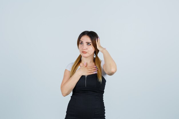 Blonde young lady in dress gesturing isolated