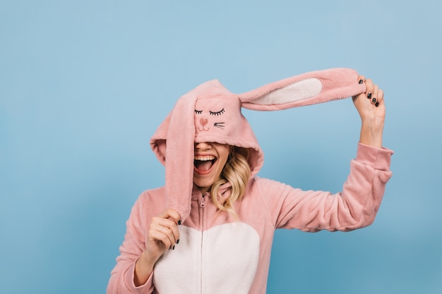 Free photo blonde young lady posing in pink bunny costume