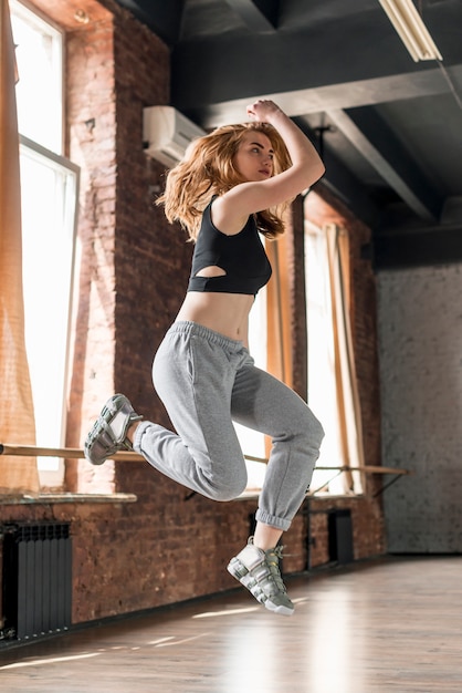 Blonde young woman dancing in the dance studio