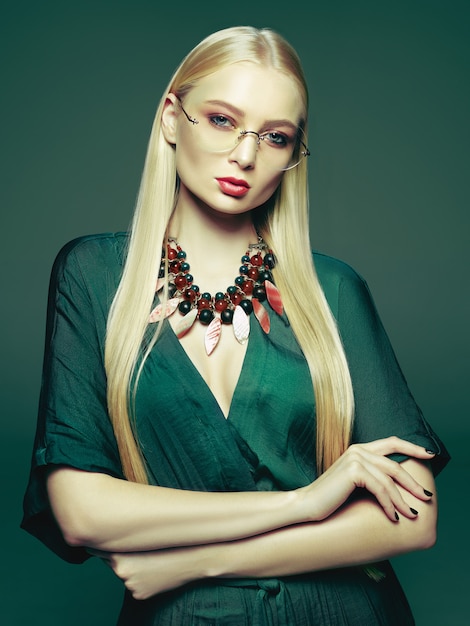 Free photo blonde young woman in elegant green dress.