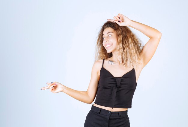 Blondie girl pointing at something on the left. 