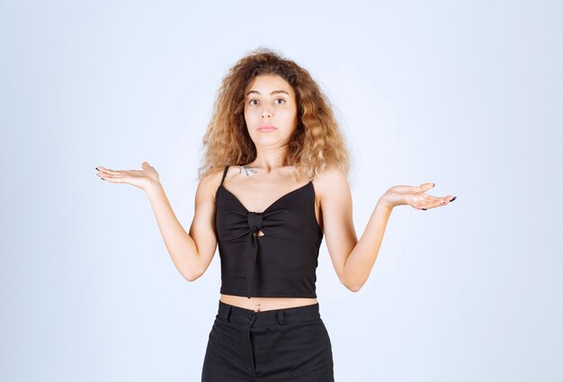 Blondie woman showing something in her hand, pointing at somewhere or giving explanation.