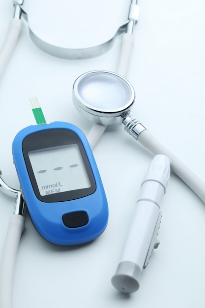 Free photo blood glucose meter and stethoscope on white background