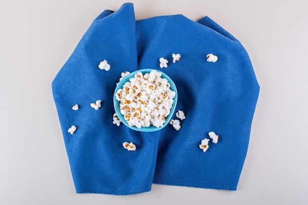 Free Photo blue bowl of salted popcorn for movie night on white background. high quality photo