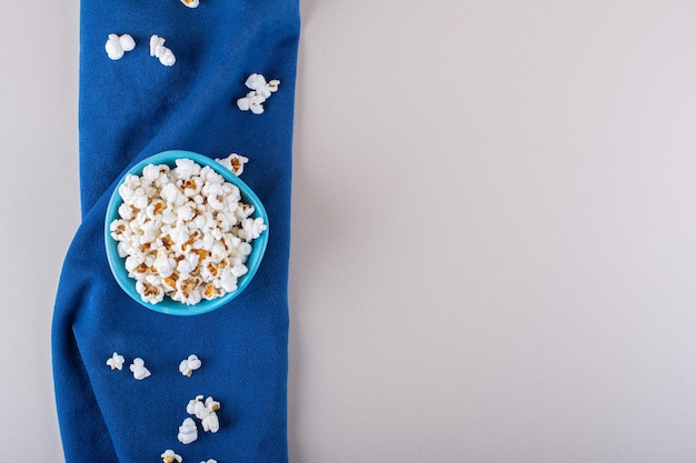 Free photo blue bowl of salted popcorn for movie night on white background. high quality photo