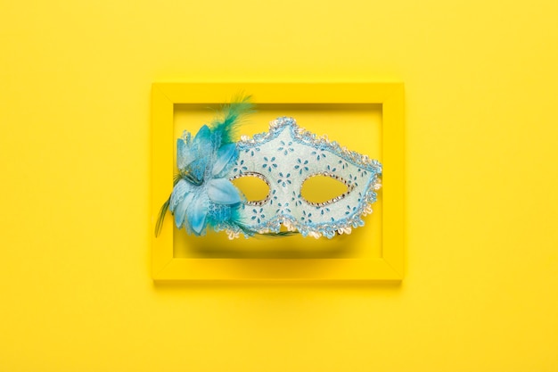 Free Photo blue carnival mask in yellow frame