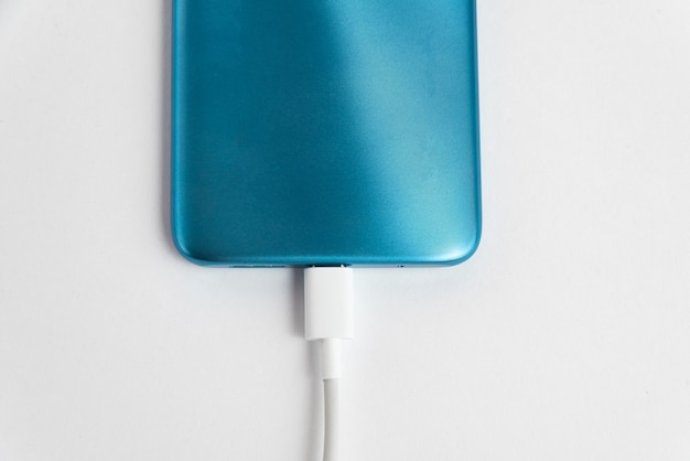 Free photo blue cell phone connected to usb cable type c - charging