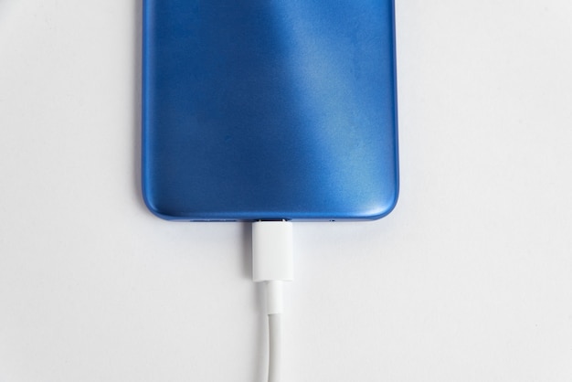 Blue cell phone connected to USB cable type - Charging