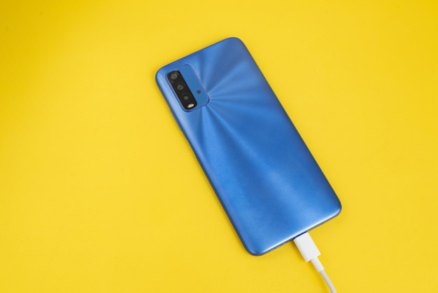 Blue cell phone connected to USB cable type - Charging