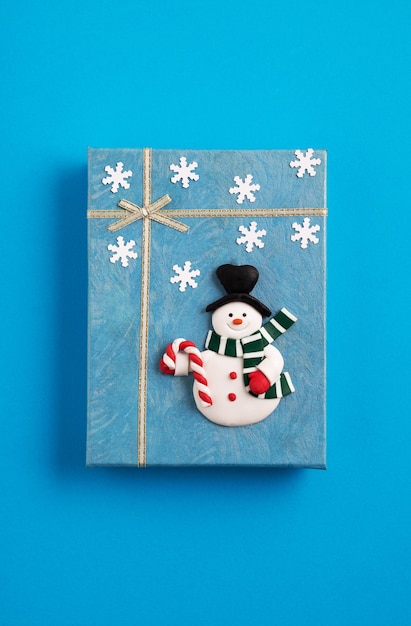 Free photo blue christmas gift box decorated with a snowman and snowflakes