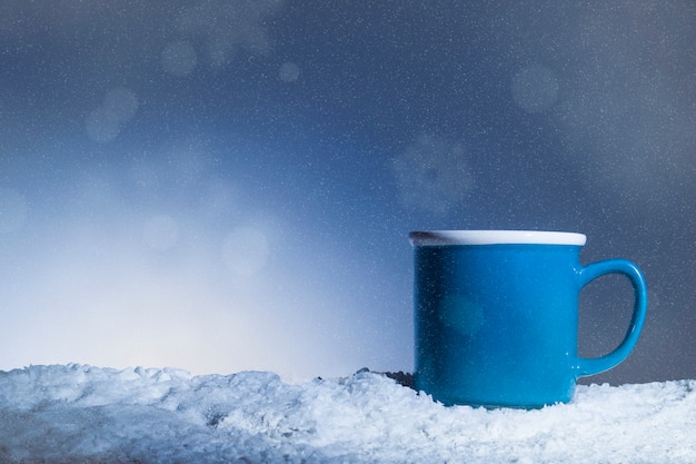 Blue cup placed on snow